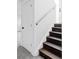 Stairway with dark treads, white risers and walls, and a light wood handrail at 9380 Raleigh Ct, Westminster, CO 80031