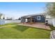 Expansive backyard featuring a covered patio, lush artificial turf, white fencing, and a built-in grill perfect for entertaining at 1498 S Perry St, Denver, CO 80219