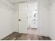 An open closet with a glimpse into a bathroom featuring a white vanity and round mirror at 1498 S Perry St, Denver, CO 80219