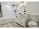 Bathroom featuring a shower/tub combination, white vanity, round mirror, and modern lighting at 1498 S Perry St, Denver, CO 80219