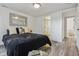 Bedroom with a black quilt, accent pillows, modern mirror and gray wood-look flooring at 1498 S Perry St, Denver, CO 80219