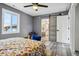 Bedroom with grey walls, ceiling fan and barn door that leads into bathroom at 1498 S Perry St, Denver, CO 80219