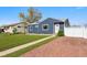 Charming home showcasing its well-manicured lawn, stone accents, and inviting curb appeal, all under a clear blue sky at 1498 S Perry St, Denver, CO 80219
