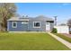 Charming home with a well-manicured lawn, modern siding, solar panels, and a welcoming walkway leading to the front door at 1498 S Perry St, Denver, CO 80219