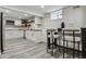 Cozy kitchen features white cabinetry, wood countertop, stainless appliances, bar table and gray wood-look floors at 1498 S Perry St, Denver, CO 80219