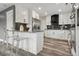 Modern kitchen featuring white cabinets, stainless steel appliances, a breakfast bar, and an open layout for easy entertaining at 1498 S Perry St, Denver, CO 80219