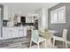 Modern kitchen with white cabinets, sleek appliances, stylish bar stools, and a cozy breakfast nook with abundant natural light at 1498 S Perry St, Denver, CO 80219