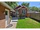 Backyard featuring a brick house with a well-manicured lawn, connecting to a brick outbuilding with a gray door at 737 Clayton St, Denver, CO 80206