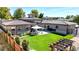 This backyard features a beautiful lawn, a covered patio with an outdoor table and chairs, and a pergola at 3299 S Newcombe St, Lakewood, CO 80227