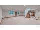 Spacious basement featuring hardwood staircase, neutral walls, carpet floors, and multiple entry doors at 3299 S Newcombe St, Lakewood, CO 80227