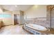 Relaxing bathroom featuring a jetted tub, tiled surround, and access to a walk-in shower at 3299 S Newcombe St, Lakewood, CO 80227