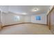 Expansive spare bedroom with neutral walls, plush carpeting, natural light, and multiple entry doors at 3299 S Newcombe St, Lakewood, CO 80227