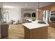 Open kitchen features an island with seating, stainless steel appliances, and access to a cozy sitting room at 3299 S Newcombe St, Lakewood, CO 80227