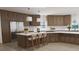 This renovated kitchen features stainless steel appliances, custom cabinets, an island, and updated countertops at 3299 S Newcombe St, Lakewood, CO 80227