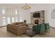 The living room boasts vaulted ceilings, large windows, wood floors, a stone fireplace, and comfortable seating at 3299 S Newcombe St, Lakewood, CO 80227