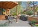 Outdoor patio area with seating, brick surround, and mature trees at 9400 E Iliff Ave # 181, Denver, CO 80231