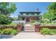 Charming two-story home with brickwork and wood pergola, steps lead to front door surrounded by flower beds at 171 N Franklin St, Denver, CO 80218