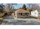 Charming home with a cozy front porch, stone exterior, and freshly graveled driveway at 1621 Trenton St, Denver, CO 80220