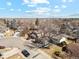 A neighborhood showcasing mature trees and houses with well-maintained lawns in a high angle shot with blue skies at 6676 Zang St, Arvada, CO 80004