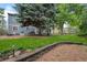 Landscaped backyard with a firepit, stone wall, and plenty of room for outdoor activities at 9963 W Canyon Ave, Littleton, CO 80127