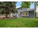 Beautiful backyard with a patio, lush green lawn, and mature trees providing ample shade at 9963 W Canyon Ave, Littleton, CO 80127