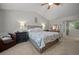Bright bedroom featuring carpet, a ceiling fan, and a bed with nightstands at 9963 W Canyon Ave, Littleton, CO 80127