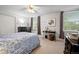 Carpeted bedroom featuring natural light, a ceiling fan, and a large bed at 9963 W Canyon Ave, Littleton, CO 80127