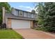 Two-story home with a large garage and driveway, brick accents, and beautiful blue siding at 9963 W Canyon Ave, Littleton, CO 80127