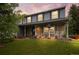 Charming two-story home featuring brick accents, a covered porch with rocking chairs, and a well-manicured lawn at 9963 W Canyon Ave, Littleton, CO 80127