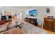 Spacious living room with a large TV, hardwood floors, and an open layout to the kitchen at 9963 W Canyon Ave, Littleton, CO 80127