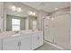 Modern bathroom with double vanity, framed mirrors, large shower with glass door at 1898 Westport Ave, Berthoud, CO 80513