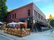 Large brick building with a restaurant and outdoor seating area, lit with warm lights at 4159 Wyandot St, Denver, CO 80211