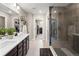 Bathroom featuring a double sink, a glass enclosed shower, and doorway to the walk in closet at 138 Lullaby Ln, Castle Rock, CO 80109