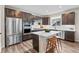 Modern kitchen featuring stainless steel appliances, an island with breakfast bar, and dark wood cabinetry at 138 Lullaby Ln, Castle Rock, CO 80109