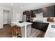 Modern kitchen features dark wood cabinets, stainless steel appliances, and a center island with seating at 138 Lullaby Ln, Castle Rock, CO 80109