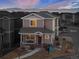 Two-story townhome with a red door, landscaping, and mountain views at 6108 Summit Peak Ct # 102, Erie, CO 80516