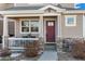 Inviting front porch with stone accents and a red door at 6108 Summit Peak Ct # 102, Erie, CO 80516