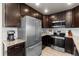 Stainless steel appliances and dark brown cabinets in this kitchen at 6108 Summit Peak Ct # 102, Erie, CO 80516