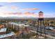 Aerial view shows a vibrant community with a historic water tower and the beautiful Rocky Mountains at 5402 Carr St # 307, Arvada, CO 80002