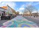Vibrant street featuring colorful street art, sidewalk cafes, and boutique shops on a sunny day at 5402 Carr St # 307, Arvada, CO 80002