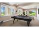 Finished basement featuring a billiard table with abundant natural light and outdoor access at 7197 Timbers Dr, Evergreen, CO 80439