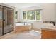 Modern bathroom featuring a soaking tub, glass-enclosed shower, and a large window with scenic views at 7197 Timbers Dr, Evergreen, CO 80439