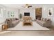 Cozy living room featuring a stone fireplace, ceiling fan, and two comfortable sofas at 7197 Timbers Dr, Evergreen, CO 80439