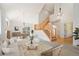 Bright, open-concept living area with vaulted ceilings, modern decor, and staircase to the second level at 7197 Timbers Dr, Evergreen, CO 80439