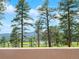 Enjoy stunning views from the covered deck, perfect for relaxation and entertaining at 7197 Timbers Dr, Evergreen, CO 80439