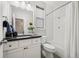 Bright bathroom with a white vanity, dark countertop, shower/tub combo, and stylish neutral finishes at 15156 W Baker Pl, Lakewood, CO 80228