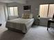Cozy bedroom features two windows and neutral tones with a striped bedspread and carpeted floor at 15156 W Baker Pl, Lakewood, CO 80228