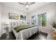 Comfortable bedroom featuring dark hardwood floors, a ceiling fan, and large windows for ample natural light at 15156 W Baker Pl, Lakewood, CO 80228