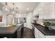 Modern kitchen with an island, stainless steel appliances, stylish pendant lights, and a wine rack at 15156 W Baker Pl, Lakewood, CO 80228