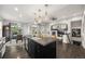 Open kitchen featuring a large center island, modern pendant lighting, and seamless integration with the living area at 15156 W Baker Pl, Lakewood, CO 80228